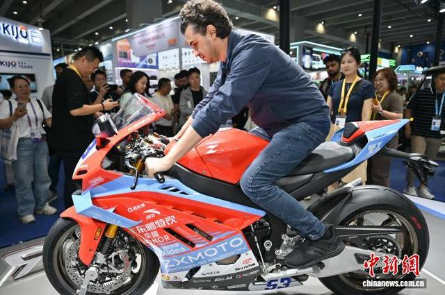 图为张雪机车展台的“冠军版赛车”820RR-R吸引境外采购商体验。中新社记者 陈楚红 摄 