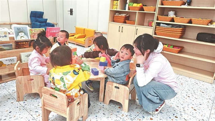 六盘水市托育综合服务中心老师带领孩子们玩游戏。  本报记者 李莎 摄