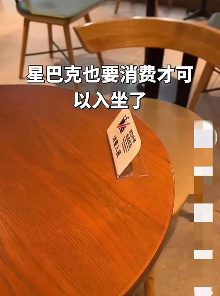 天津一家星巴克桌上放着“消费入座”牌。图/社交平台截图
