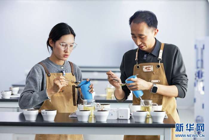 保山中咖食品有限公司负责人杨竹（右）和同事在做咖啡杯测（摄于1月14日）。新华网 赵普凡 摄