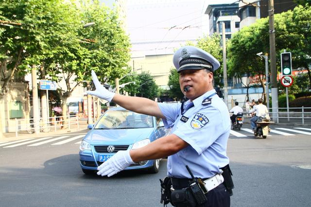 原上海市公安局静安分局交管支队民警唐立宏在马路上执勤。采访对象供图