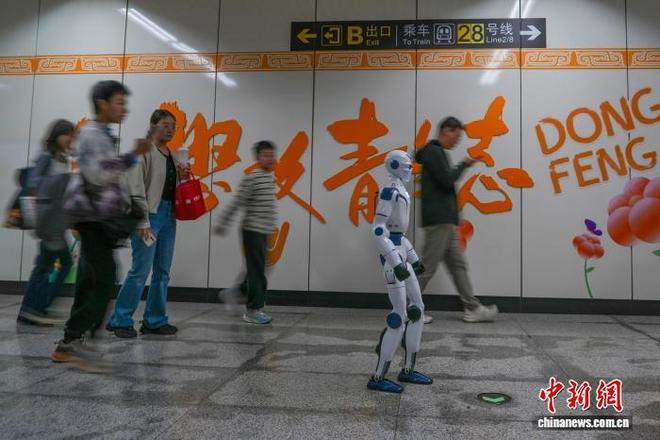  10月18日，河南郑州，市民与机器人在地铁东风路站同行。中新网记者 范晓恒 摄