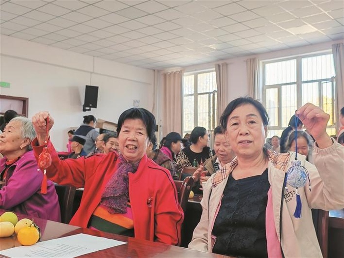     10月13日，在十三师红星一场红桥社区重阳节活动中，老人展示亲手制作的中药香囊。    兵团日报常驻记者  王晓燕  通讯员  王茜  摄