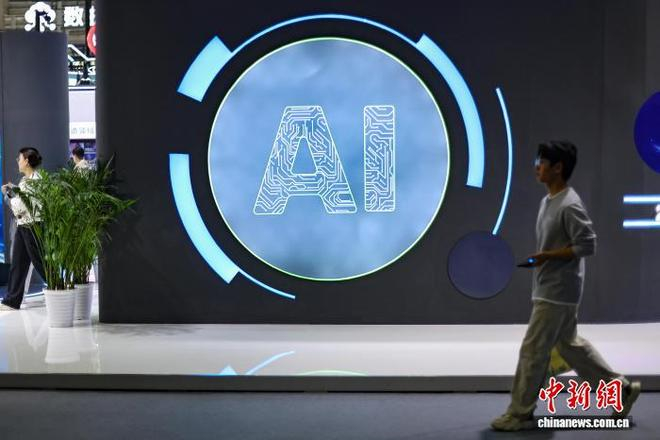  10月21日，在江苏南京举行的2026物理AI与世界模型大会展览现场，观众从“AI”展板前走过。中新社记者 泱波 摄