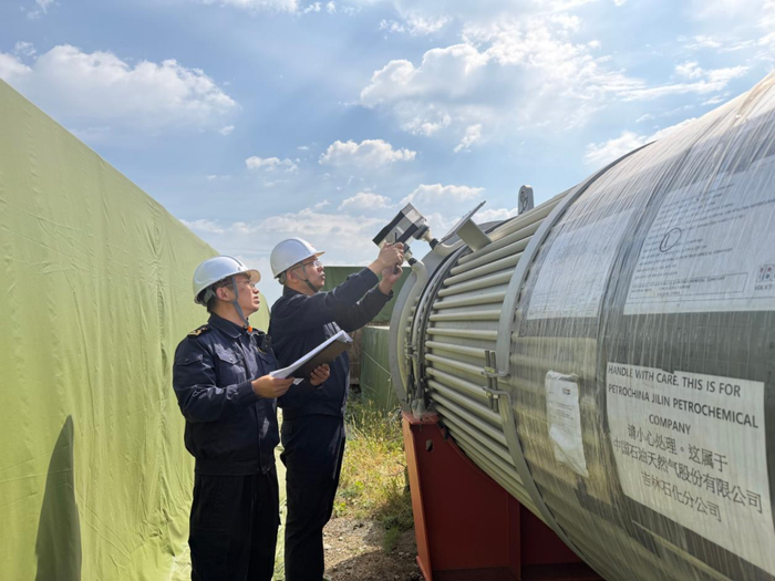 吉林海关两名关员在吉林石化转型升级EVA项目施工现场对软分离器等进口设备实施现场查验。（受访者供图）