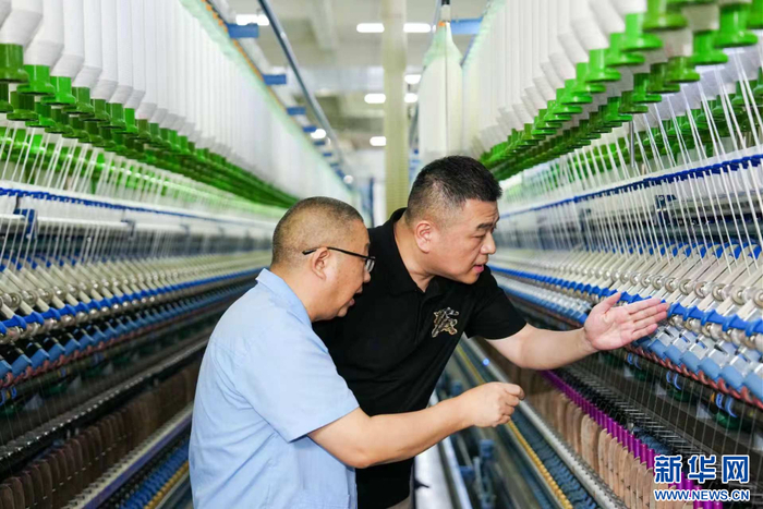 宋林木（右）在福建富兰智能光学技术有限公司生产车间内检查生产情况。新华网发（受访者供图）