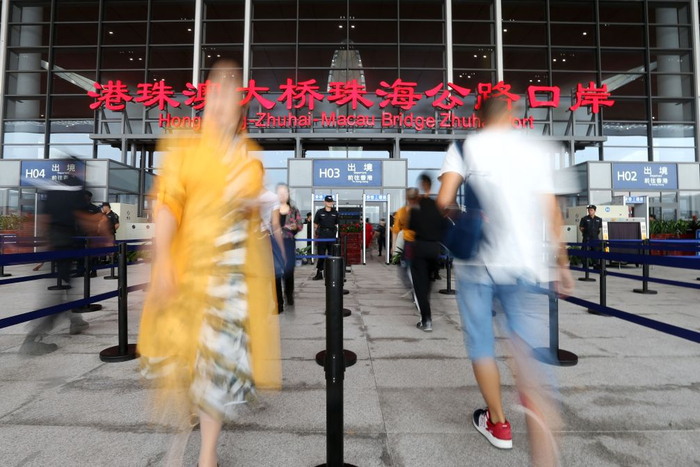   港珠澳大桥正式通车当天，人们穿梭在港珠澳大桥珠海公路口岸安检口前（2018年10月24日摄）。新华社记者 张加扬 摄