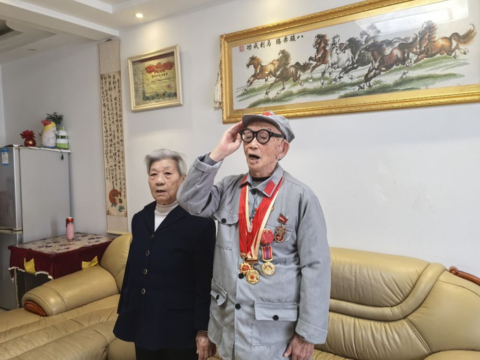   百岁老兵陈大国收看纪念中国工农红军长征胜利90周年大会新闻时，主动起身敬礼。（受访者供图）