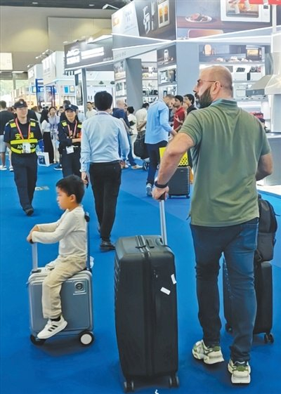 广交会上，外国采购商拉着行李箱寻找心仪产品。人民日报记者 王东辉摄