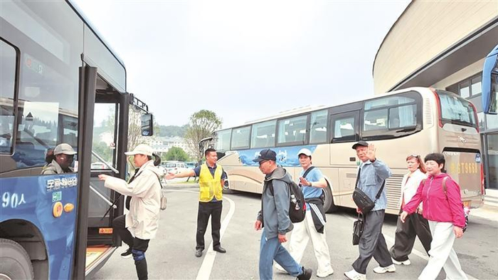 贵州黄果树旅游发展有限公司运营中心观光车驾驶员殷洪指引游客有序乘车。       本报记者 胡玉山 摄