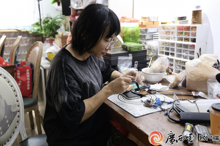 韦佳妮正在制作皮艺挂件。通讯员 黄金兰 摄