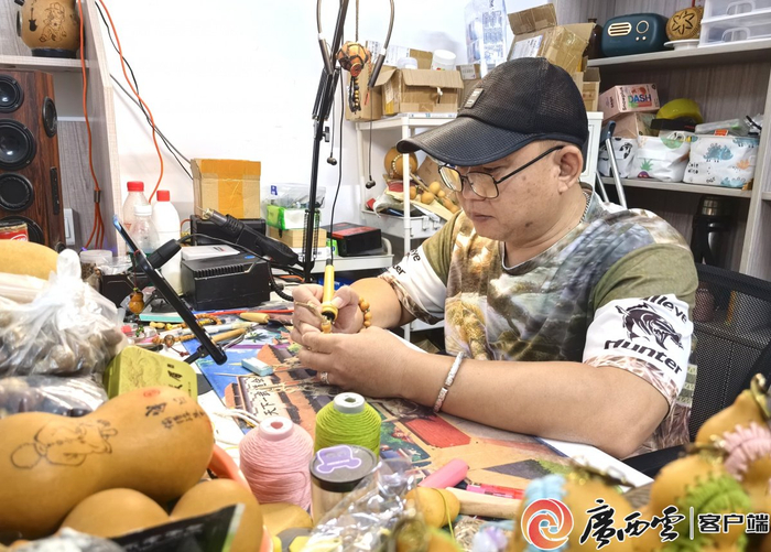 力明在葫芦上“绘”画。广西云-广西日报记者 江宏坤/摄