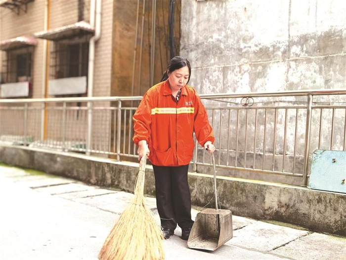 吴洪燕在黑岩湾巷清扫垃圾。本报记者 万芬 摄