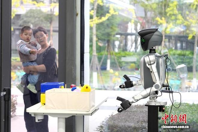 图为小朋友隔窗参观机器人。中新社记者 安源 摄