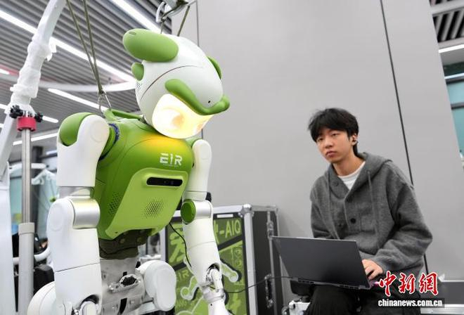 图为工程师对机器人进行检测。中新社记者 安源 摄