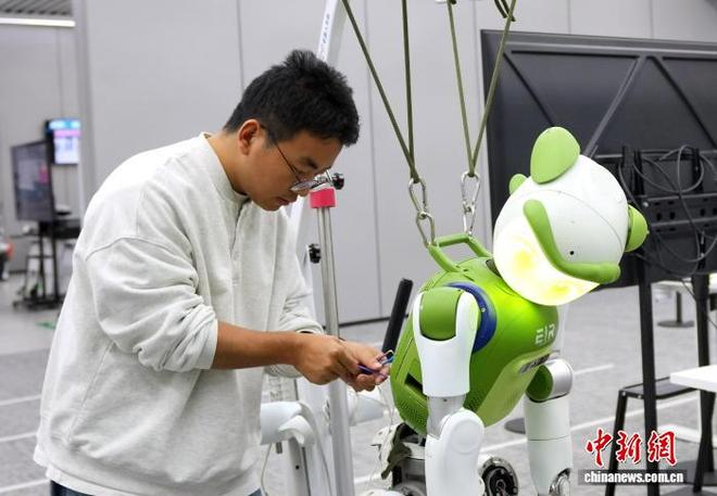 图为工程师在维修机器人。中新社记者 安源 摄