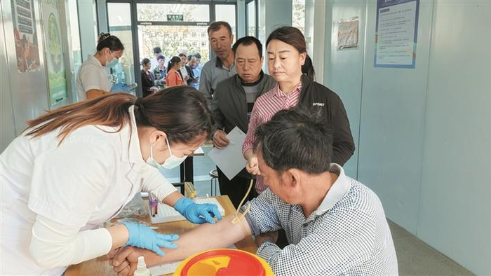 十一师流动医疗服务队医护人员在位于九师白杨市的项目工地为施工人员体检（资料图片）。 艾文娟 摄