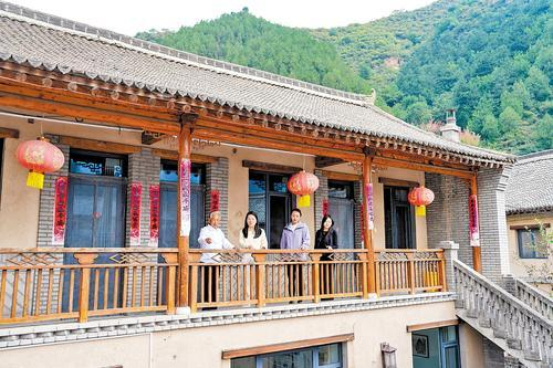     近日，骆驼湾村村民在自家民宿向游客介绍骆驼湾村的变化。本报记者 许佳奇摄