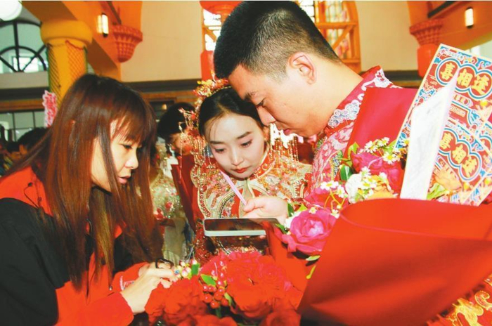         福彩工作人员在指导新人用手机兑奖。 抚顺福彩供图