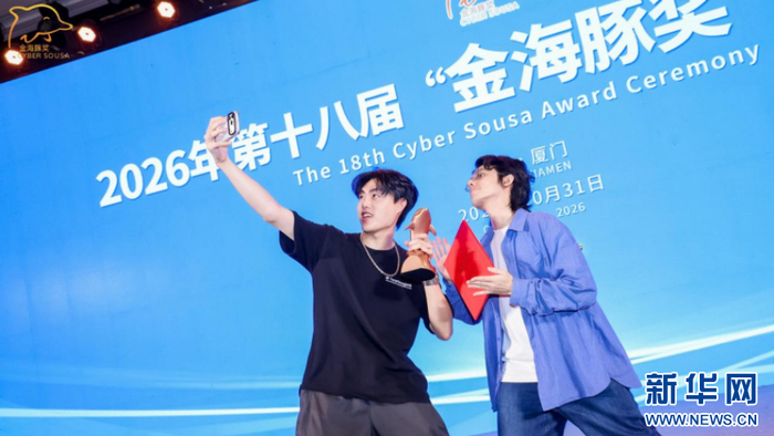 获奖者捧着金海豚奖杯与获奖证书，在舞台上自拍留念，分享斩获大奖的喜悦。新华网发（主办方供图）