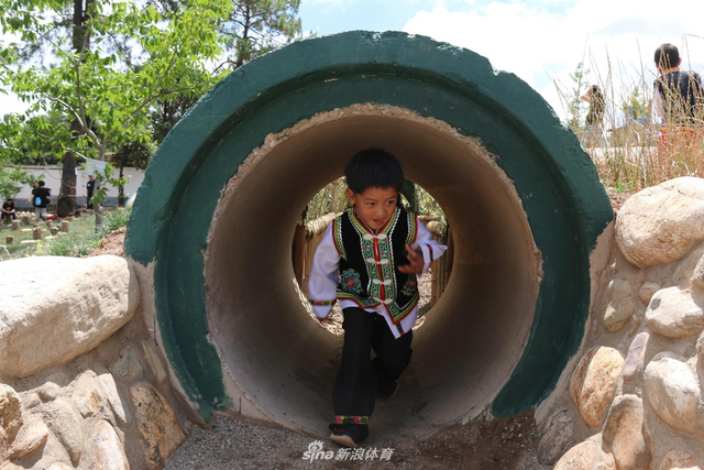 儿童在户外游乐区钻隧道