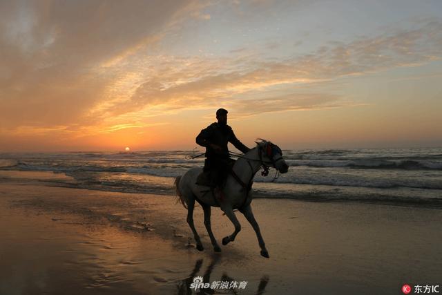 当地时间2018年1月3日,巴勒斯坦,加沙少年海边骑马,夕阳映衬分外妖娆