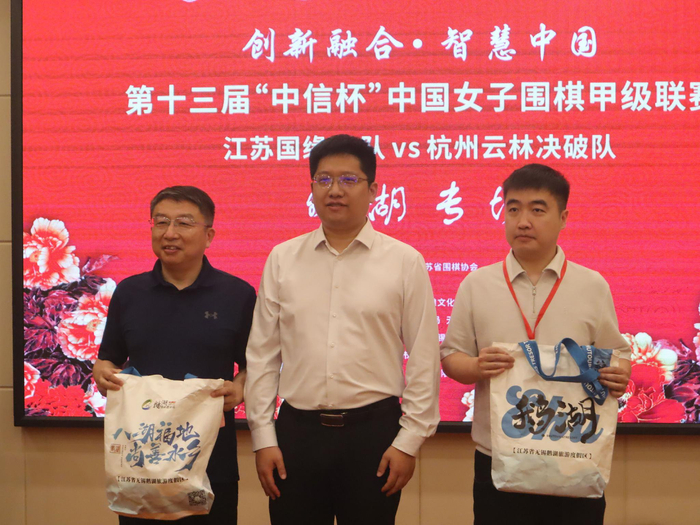 鹅湖镇镇长牟晟向两队领队教练朱晓军、陈潇楠赠送文创纪念品。