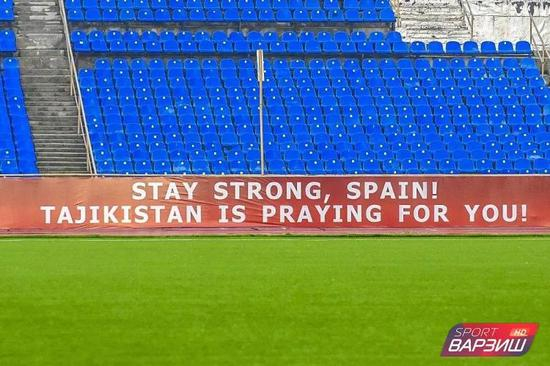 ▲转播视角下，塔吉克斯坦联赛场边广告牌上为西班牙祝福