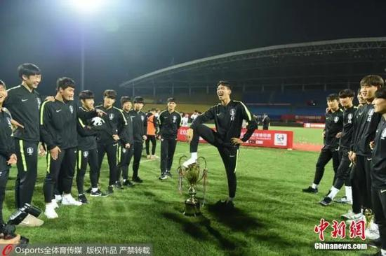 资料图：2019年在成都举办的“熊猫杯”比赛中，韩国国青战胜中国国青后以三战全胜战绩夺冠。赛后有韩国球员脚踩“熊猫杯”冠军奖杯庆祝胜利。图片来源：Osports全体育图片社