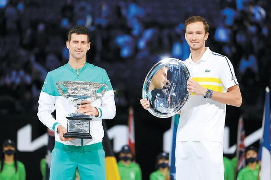 男单冠军德约科维奇（左）和亚军梅德韦杰夫在澳网颁奖仪式上。供图/东方IC