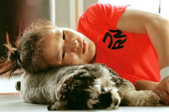 张伟丽靠在爱犬身上