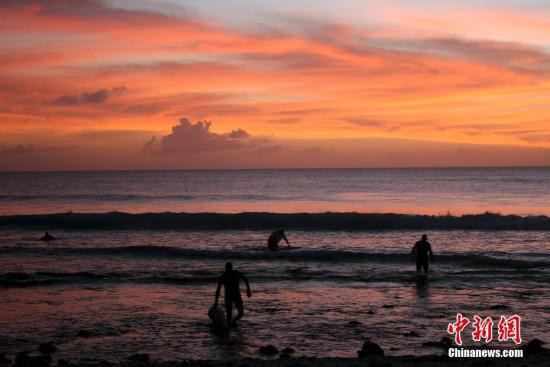 　资料图：夕阳西下，在海边的冲浪者。图片来源：视觉中国