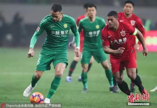 资料图：北京中赫国安队外援奥古斯托持球突破上海上港外援胡尔克在比赛中争抢。图片来源：Osports全体育图片社