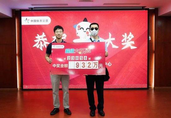 市体彩中心办公室主任陈旺华（左）为大奖得主老曾颁奖