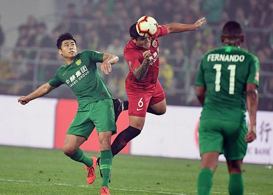 上海上港队蔡慧康（红衣）头球进攻。 毛建军（摄影部）/中新社/视觉中国