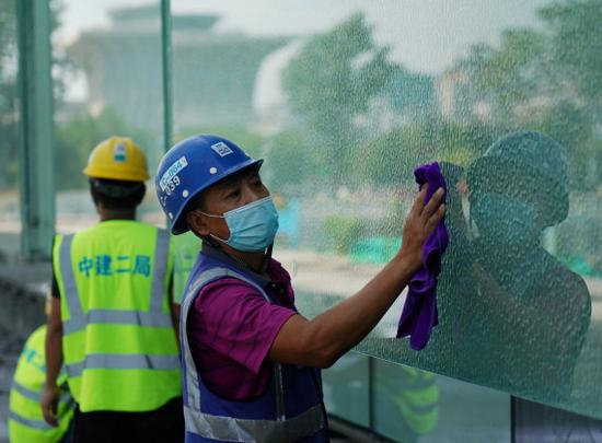 8月25日，工人在擦拭国家体育馆扩建部分玻璃幕墙。新华社记者张晨霖摄
