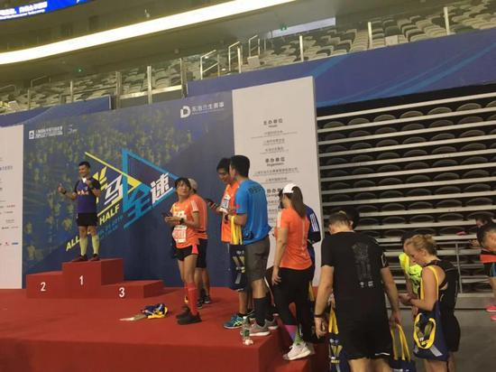 （赛后跑者排着队上领奖台拍照过过瘾。没人为这个维持秩序，自觉排队！包括存衣车前自动排队。晚到的都先询问这是几号车的排队？上海跑者这个素质还是蛮赞的！）