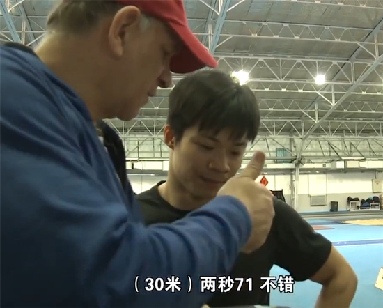 图说：外籍教练亨廷顿在和苏炳添交流训练内容。