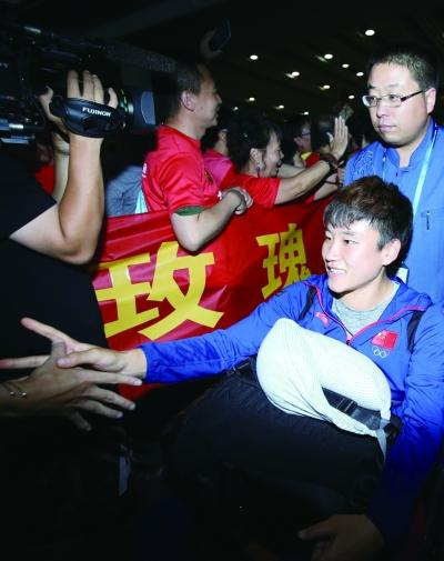 最后一战受伤的庞丰月坐在轮椅上，被工作人员推出来