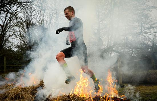 当地时间2017年1月29日，英国越野挑战赛上选手穿越火海。资料图