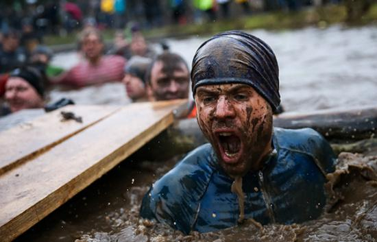 当地时间2017年1月29日，英国举行越野挑战赛，选手跳入泥潭。资料图