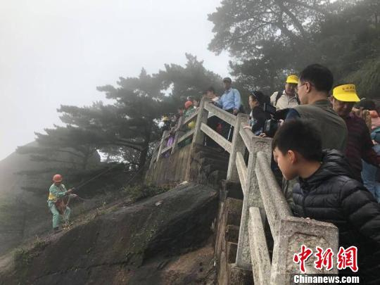 李培生在悬崖上拾捡垃圾，受到游客关注 侯晏 摄