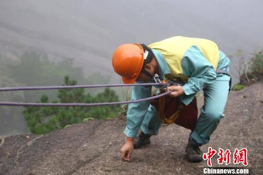 放绳工在悬崖上拾捡垃圾 汪钰 摄