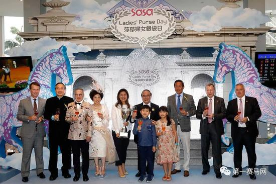 　　香港赛马会主席叶锡安博士（右三）、董事叶澍堃（左二）、行政总裁应家柏（右二）、赛事规管及发展执行总监夏定安（左）、赛马业务及营运执行总监祁立贤（右）、莎莎国际控股有限公司主席及行政总裁郭少明博士、副主席郭罗桂珍博士与得胜马匹“创世纪”的马主萧剑莹及家人在祝酒仪式上举杯，庆祝本年度莎莎妇女银袋日圆满成功，图来自香港马会