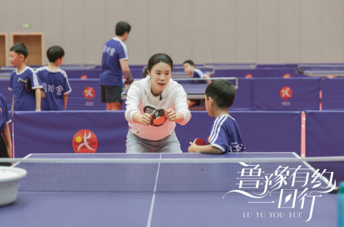 图：王楠在教孩子打球