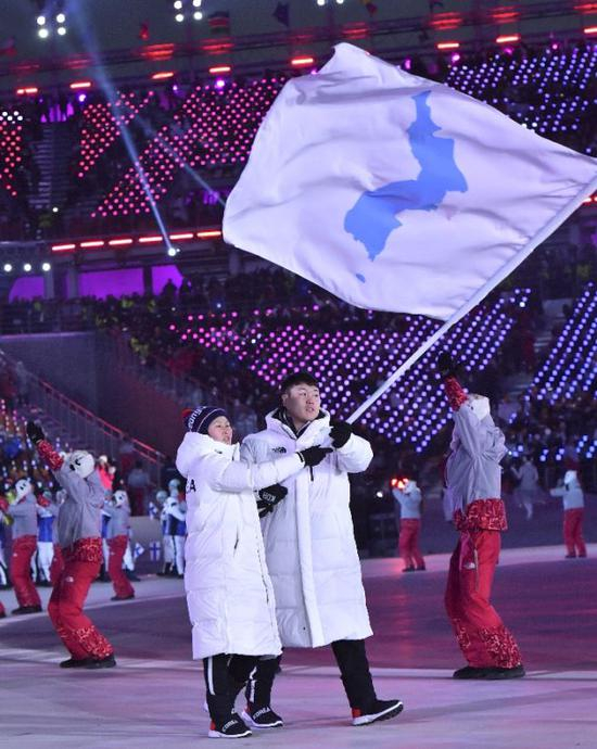 2月9日，朝韩两国代表团旗手黄忠琴（左）与元允宗在开幕式上举“朝鲜半岛旗”共同入场。当日，2018年平昌冬奥会开幕式在平昌奥林匹克体育场举行。新华社记者 吕小炜 图