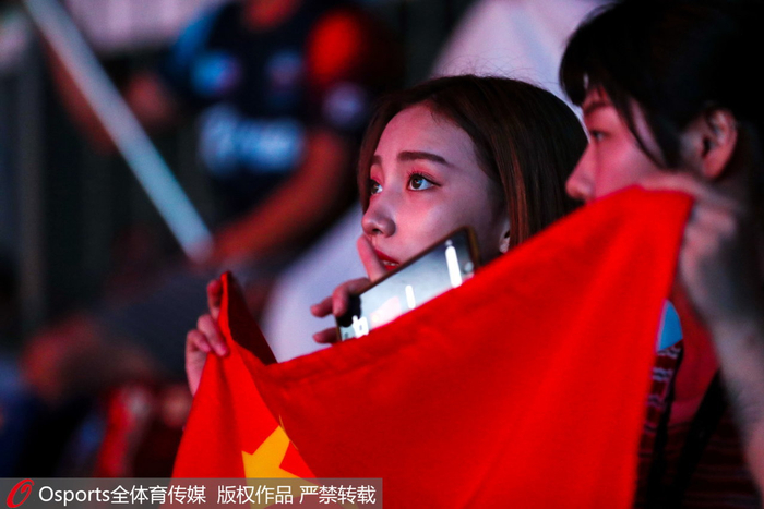 现场拿国旗的女观众。