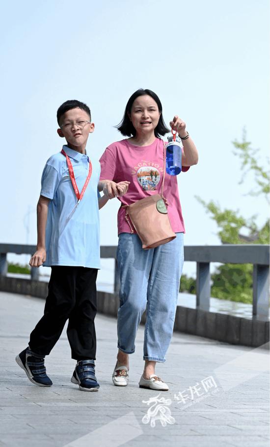 妈妈柴娜牵着儿子雨雨（化名）参加重庆市第七届运动会围棋赛项比赛。