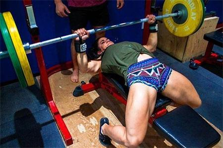 Stefanie Cohen正在做杠铃卧推，手臂肌肉清晰可见。