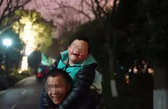 “拼命三郎”背着儿子微笑面对未来。